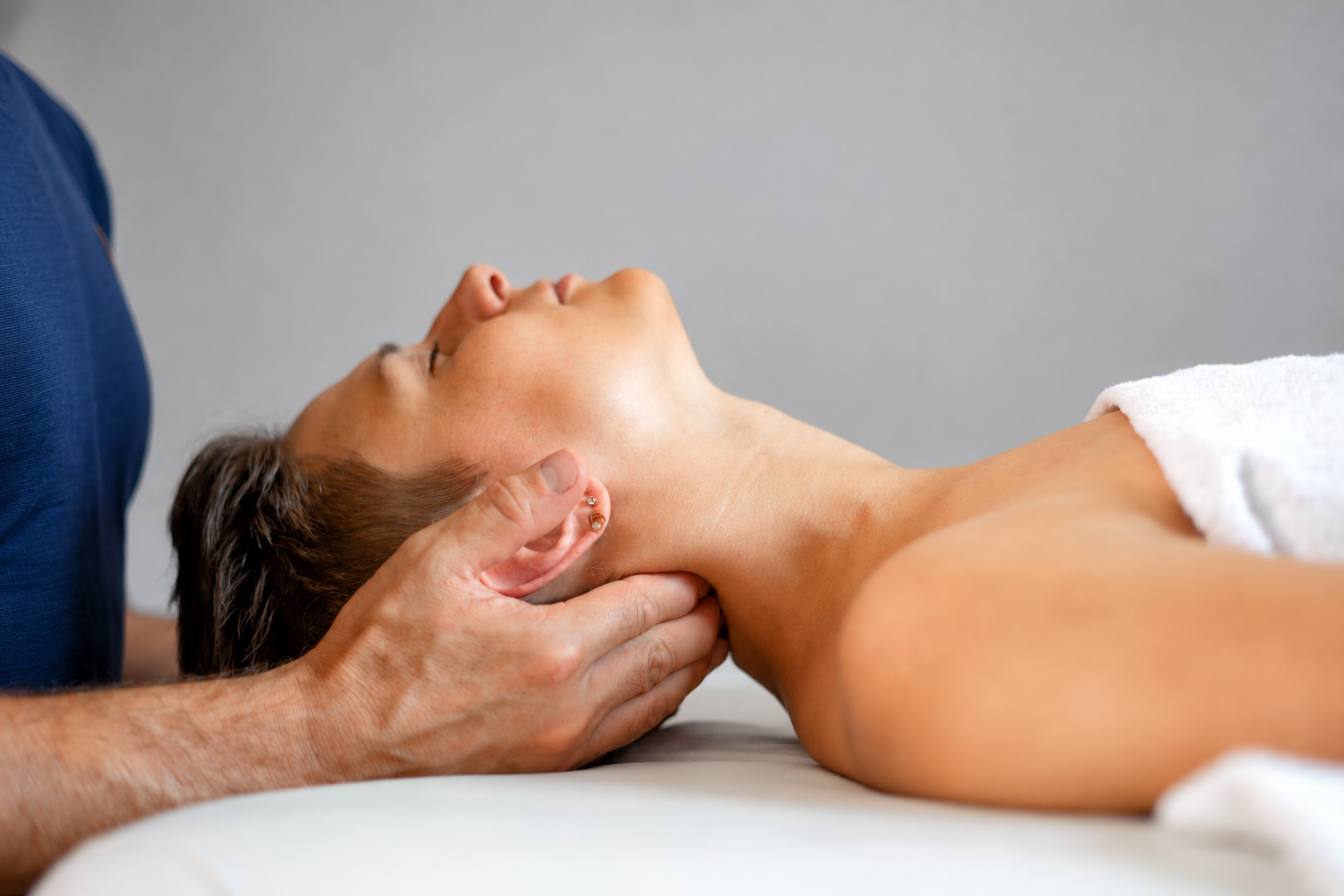 Mark Bailey providing gentle hands-on neck massage therapy to a client