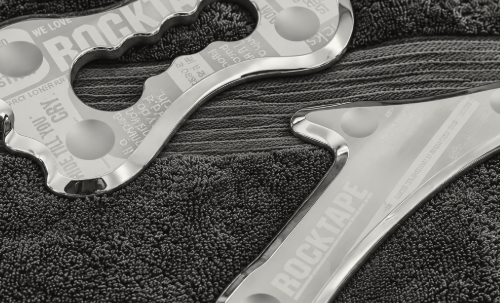 RockBlades IASTM stainless steel soft tissue therapy tools resting on a navy towel