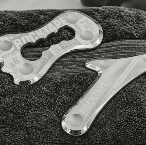 RockBlades IASTM stainless steel soft tissue therapy tools resting on a navy towel