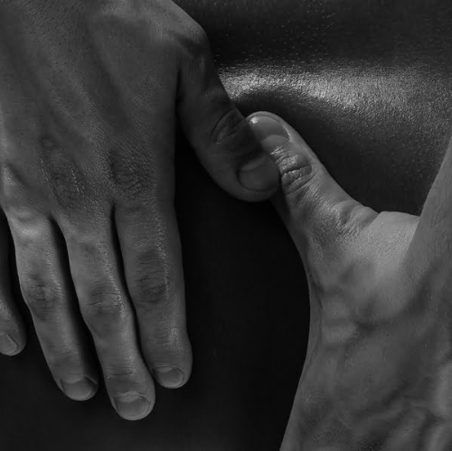Massage therapist applying hands-on treatment to a client's back.